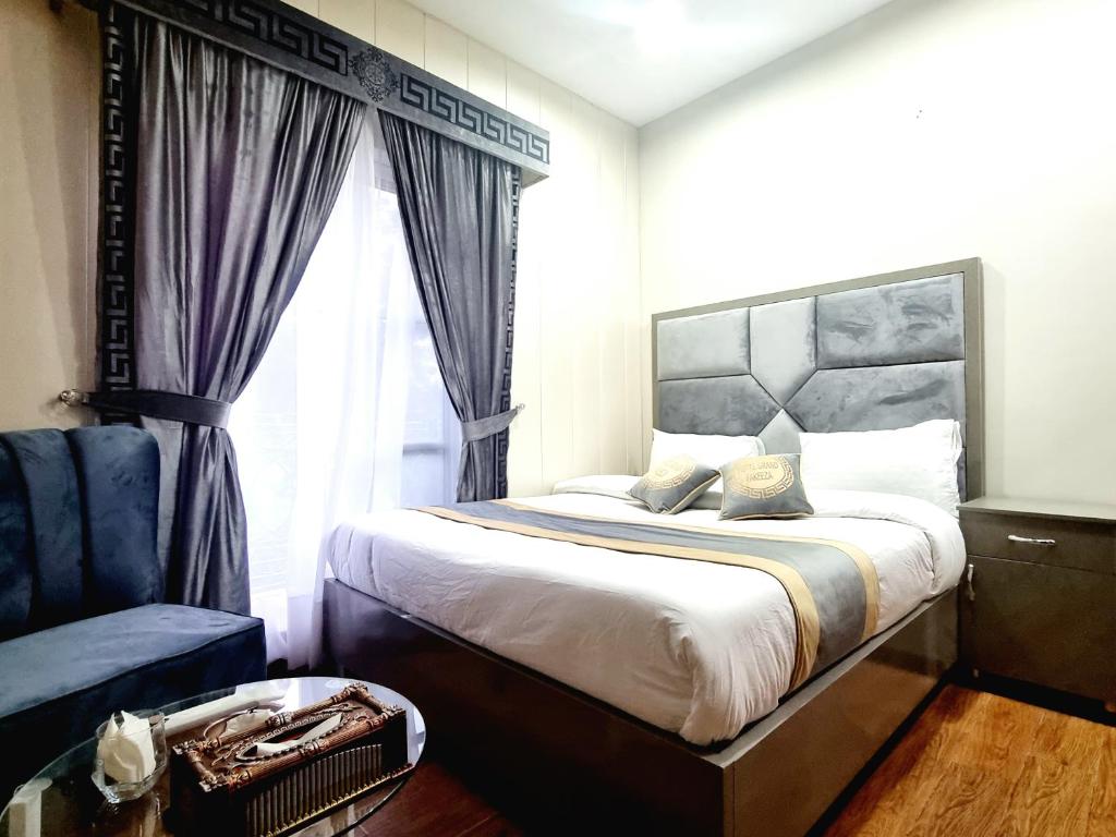- une chambre avec un grand lit et une fenêtre dans l'établissement Hotel Grand Pakeeza, à Lahore