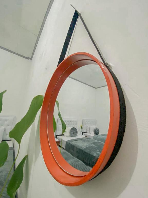 a mirror hanging on a wall next to a bed at Lorent Hostel Near Padang Beach in Padang