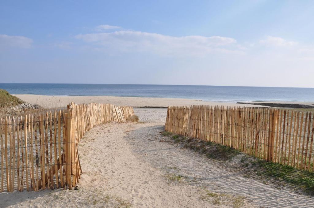 uma cerca de madeira numa praia junto ao oceano em Location de vacances en Bretagne sud em Névez