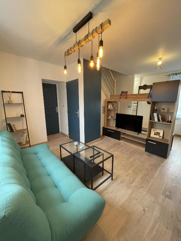 ein Wohnzimmer mit einem Sofa und einem TV in der Unterkunft Le Dalhia - Campagne - 6 pers - Rêve au Mans in Noyen-sur-Sarthe