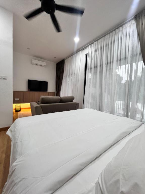 um quarto com uma cama e uma ventoinha de tecto em Jenderam Hill Villa em Sepang