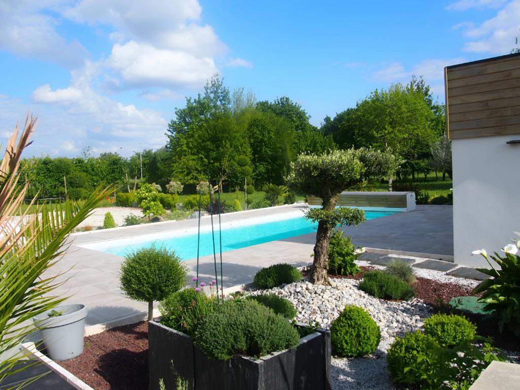 a garden with a swimming pool in a yard at L'Ecolière - Villa Piscine Chauffée - Rêve au Mans in Teillé