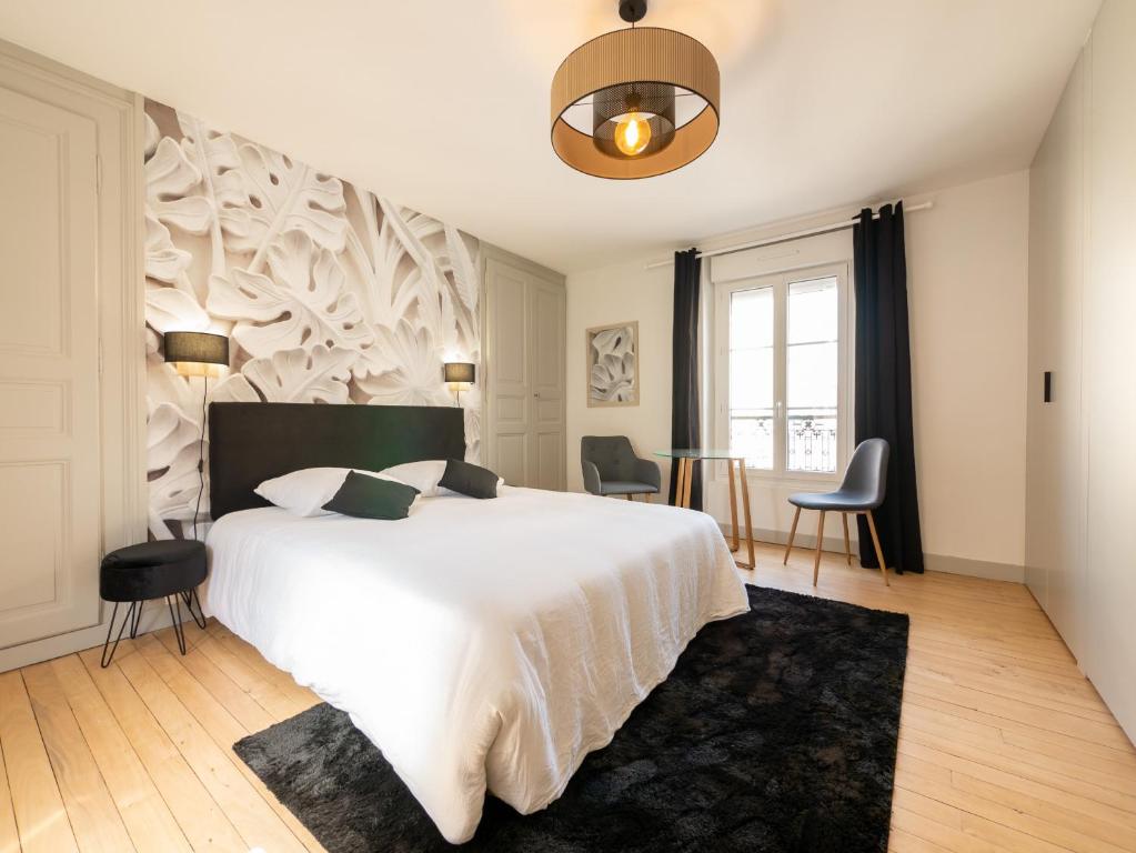 sypialnia z dużym białym łóżkiem i krzesłami w obiekcie Le Night Dream - Sauna - Gare - Palais des Congrès - Rêve au Mans w mieście Le Mans