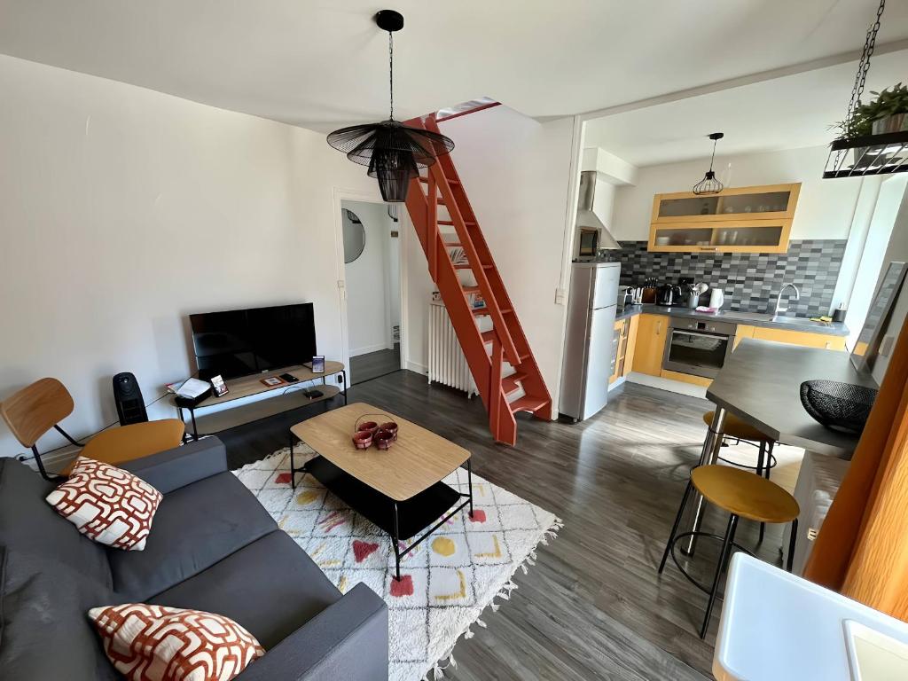 a living room with a couch and a kitchen at Terracotta - 5 pers - hyper centre - Rêve au Mans in Le Mans