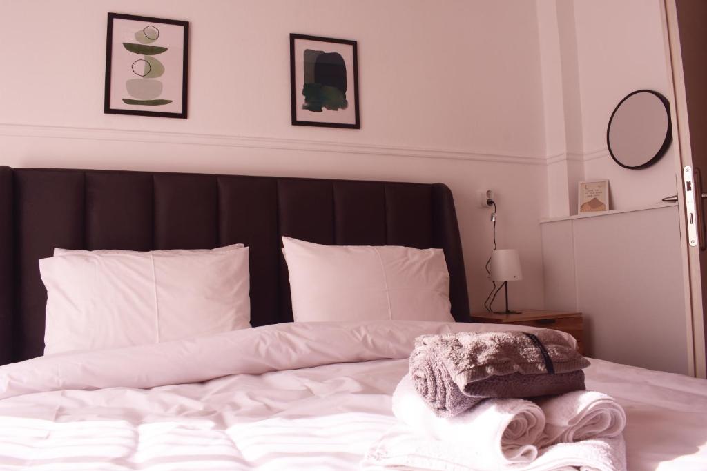 1 dormitorio con 1 cama con sábanas y almohadas blancas en Antonia's city apartment en Ioánina