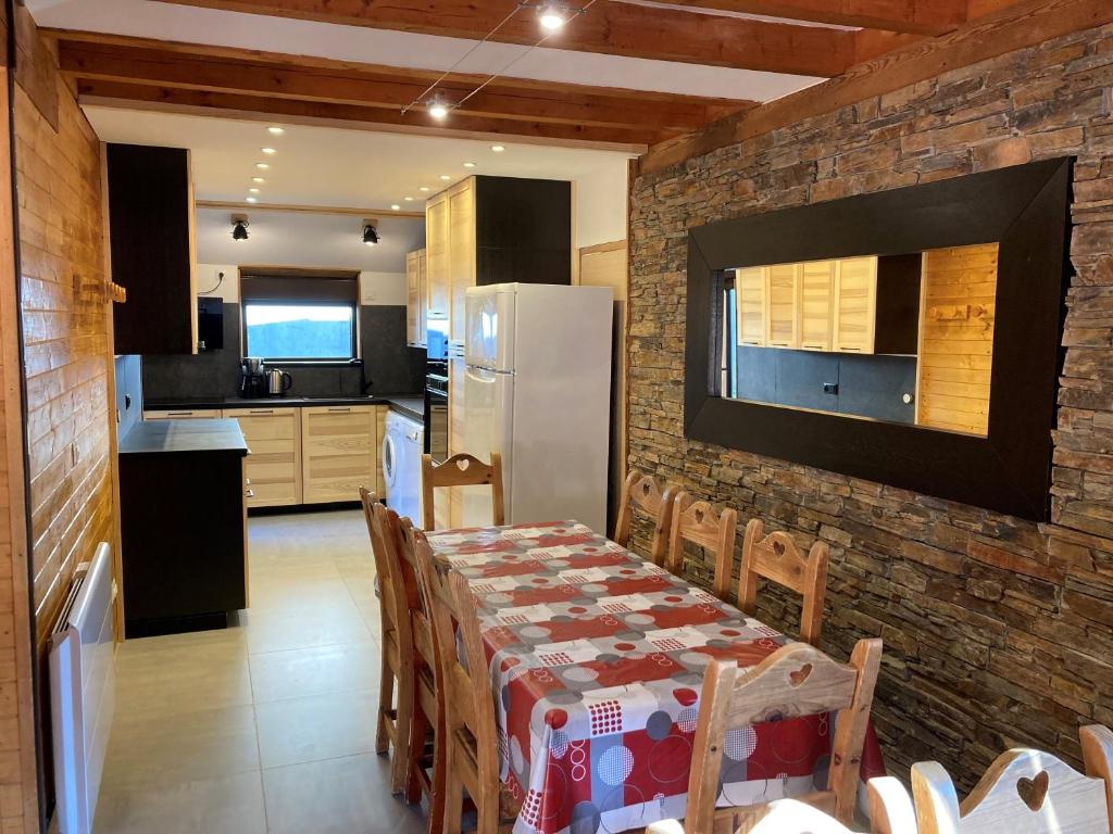 a kitchen with a table and a refrigerator at Chalet Flocon in Les Deux Alpes