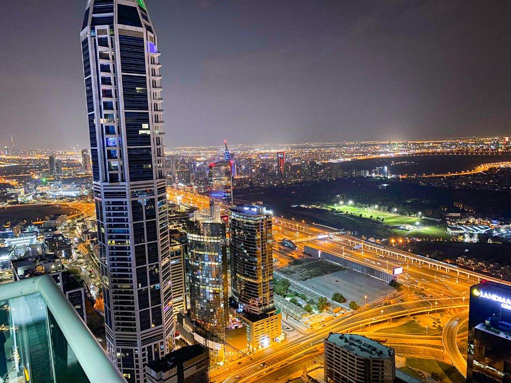 eine Skyline der Stadt in der Nacht mit einem hohen Gebäude in der Unterkunft Hawana Premium Hostel in Dubai