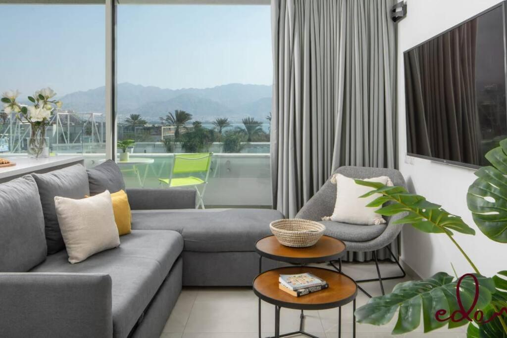 a living room with a couch and two chairs at דירת חדר שינה וסלון עם מרפסת ליד הים - By Edomlux in Eilat