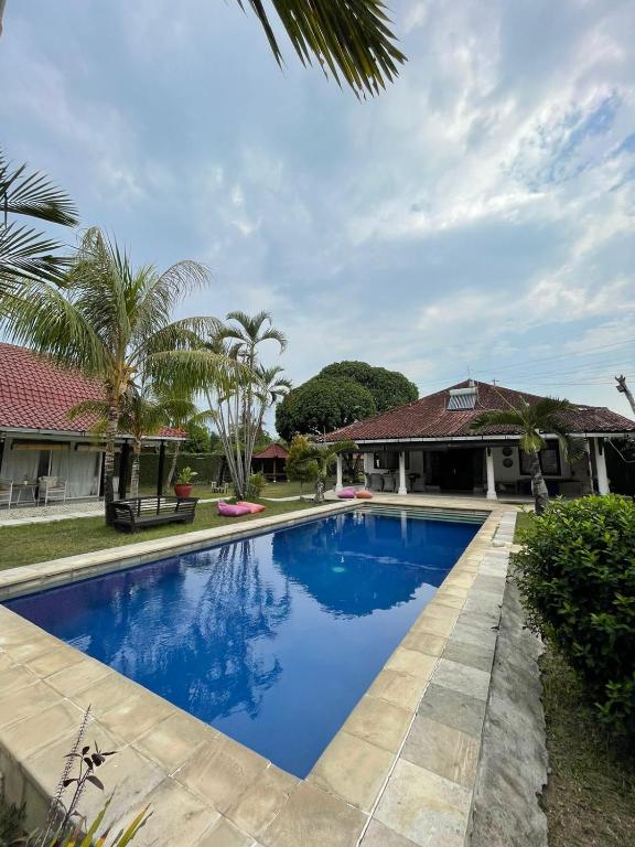a swimming pool in front of a house at Le Kekeri Villas Collection in Mataram