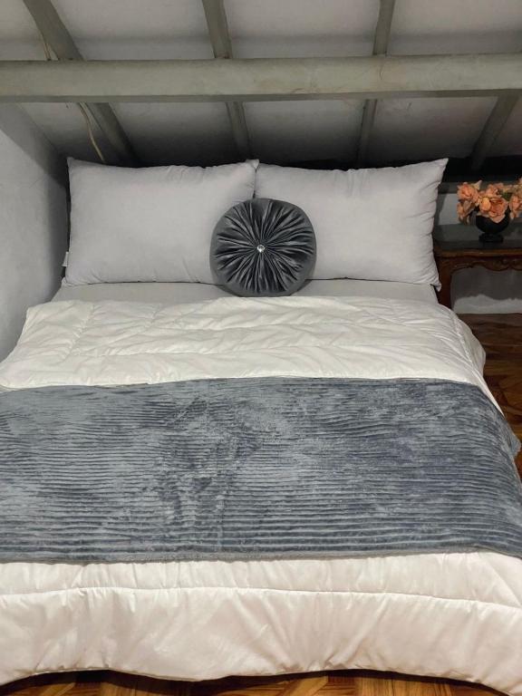a bed with a black and white pillow on it at Lorent Hostel Near Padang Beach in Padang