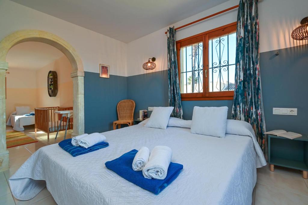 a bedroom with a large bed with towels on it at El Signo de Aries in Jávea