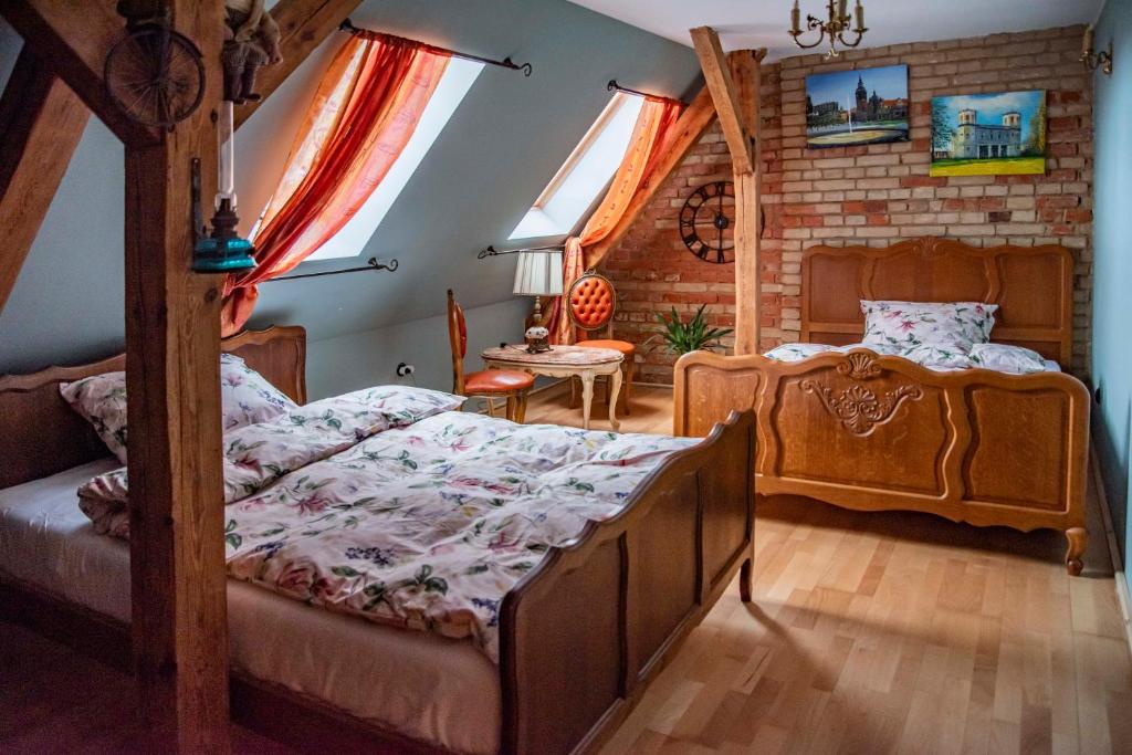 Dawny Dom في Płoty: غرفة نوم بسريرين وطاولة في غرفة
