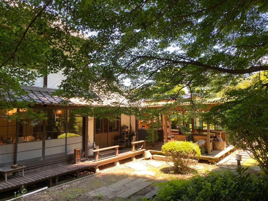 uma casa com um banco à frente em Antique Villa Lotus（古民家ロータス） em Tsukuba
