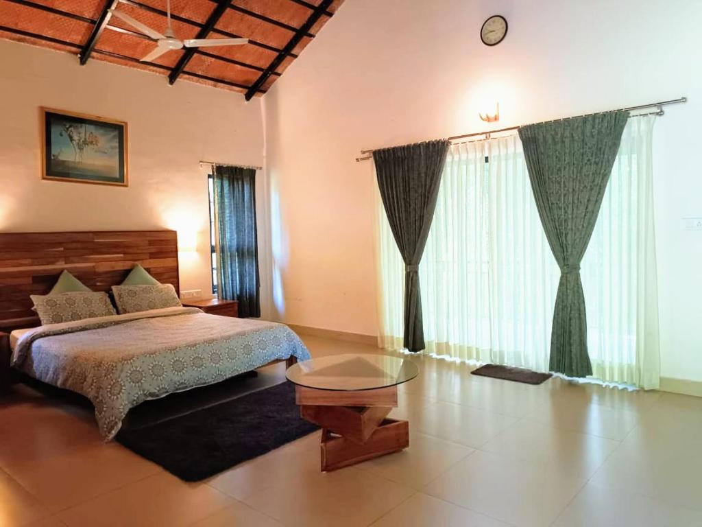 um quarto com uma cama e uma mesa em The Road's End em Gonikoppal