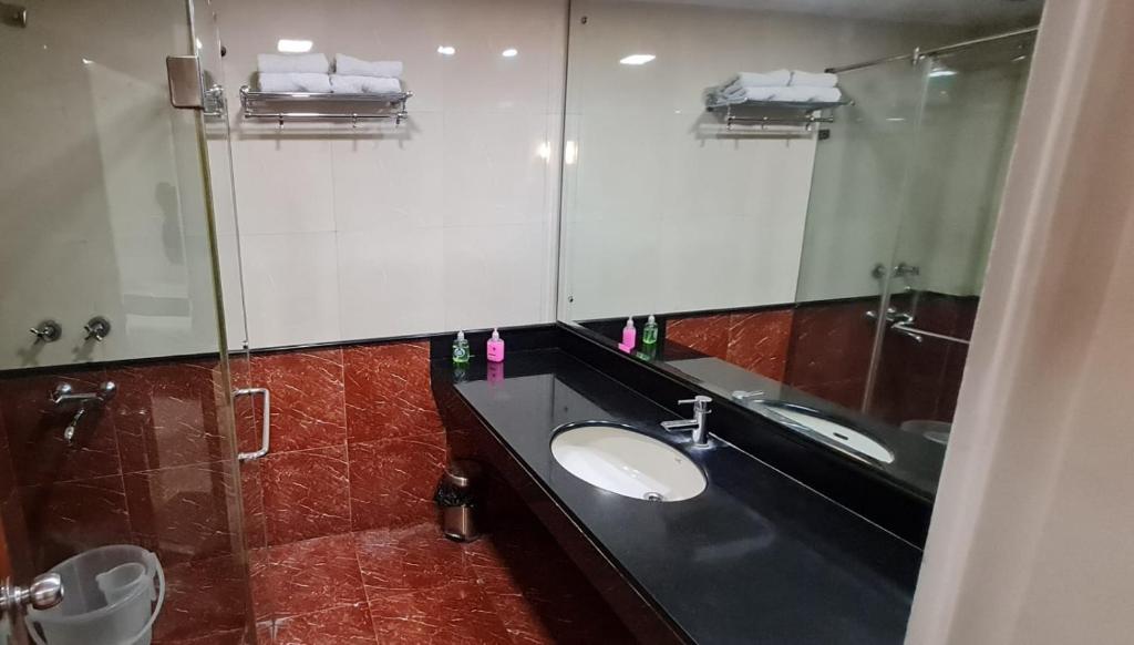 a bathroom with a sink and a mirror at Hotel Divine Admire Opp Gurudwara Sahib in Taimoor Nagar-Friends Colony in New Delhi