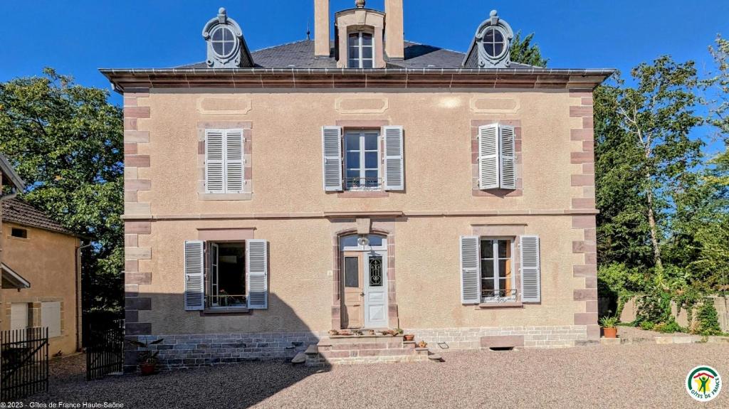 a large brick building with a tower on top at La Closerie des Anges in Saulx-de-Vesoul