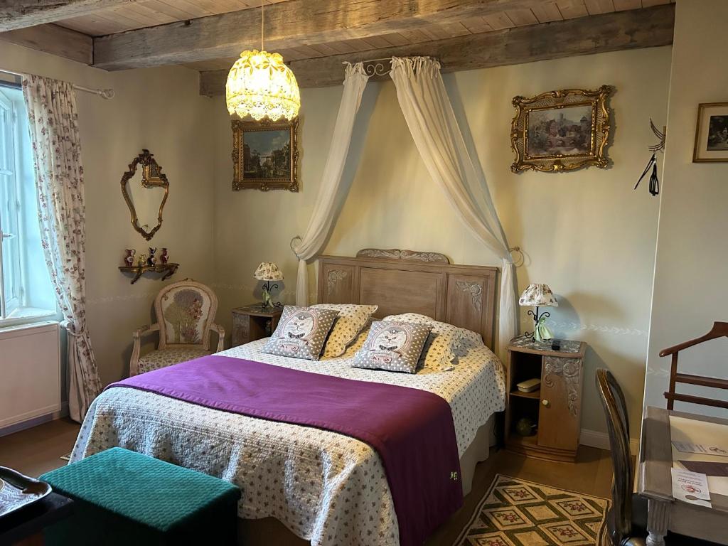 a bedroom with a bed and a chandelier at Le Château de Failloux in Épinal