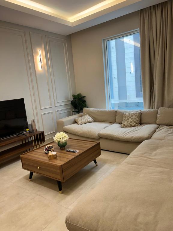 sala de estar con sofá y mesa de centro en شقة في حي الروضة الراقي en Yeda