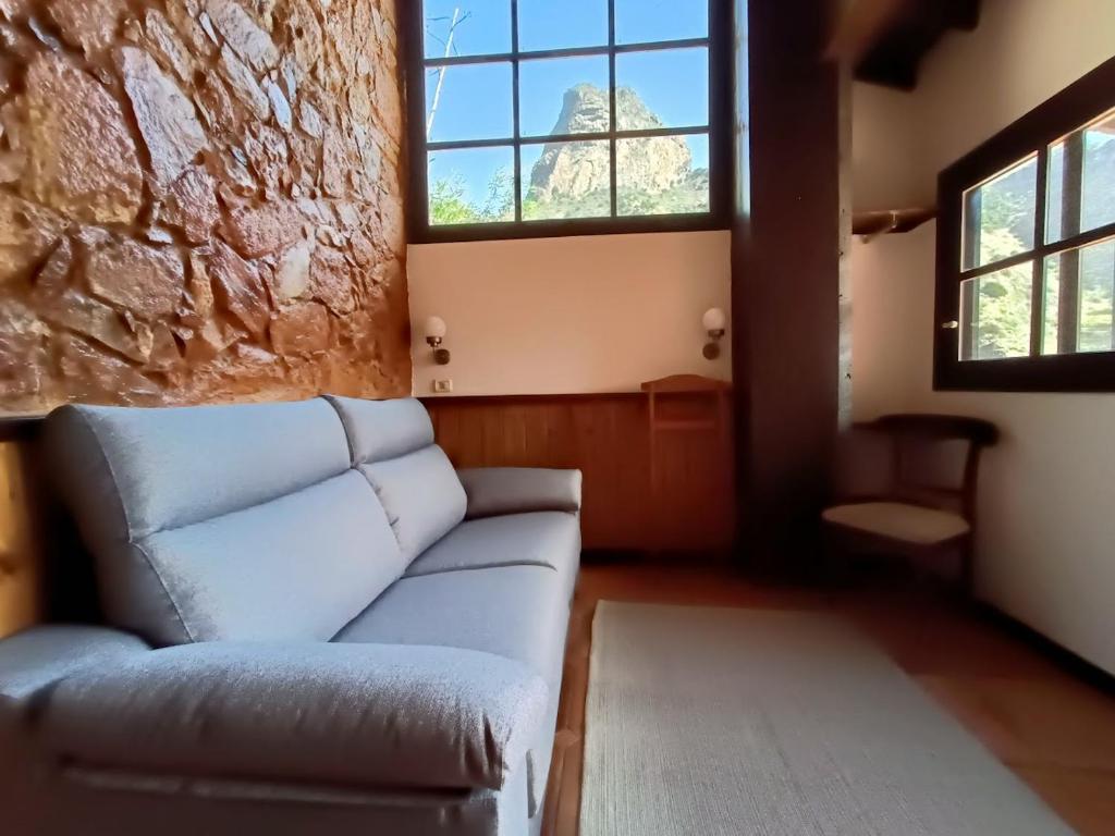 a living room with a couch and two windows at Tamahuche Hotel Rural in Vallehermoso