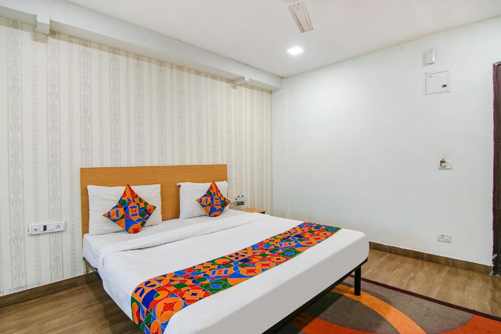 新德里的住宿－FabHotel Moro Rohini Sector 11，卧室配有一张带彩色枕头的大型白色床。