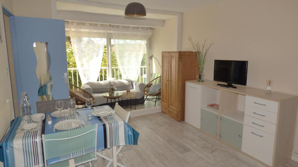 un salon avec une table et un canapé dans l'établissement Charmant T2, cabine, parking, Les Balcons de la Méditerranée, Narbonne Plage, à Narbonne-Plage
