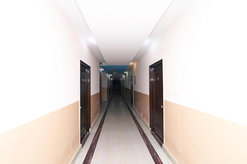 un pasillo vacío en un hospital con puertas abiertas en OYO 13161 Apni Havali Hotel & Restaurant, en Rāmpura