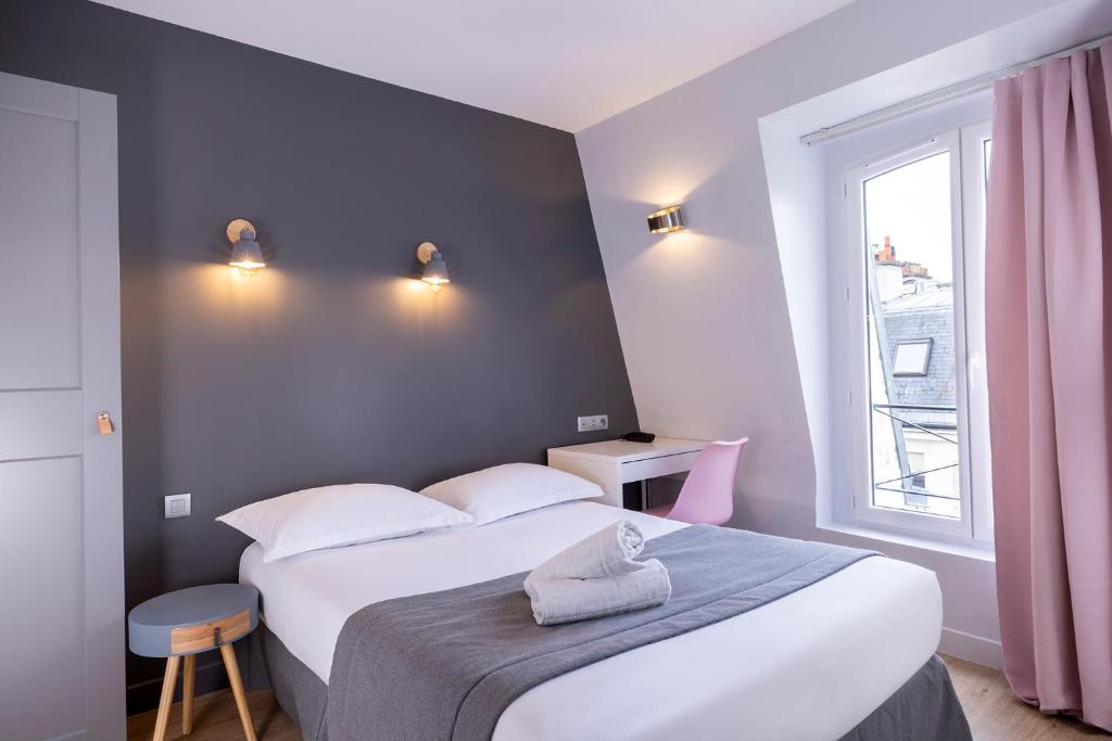 a bedroom with a large white bed and a window at Paris Legendre in Paris