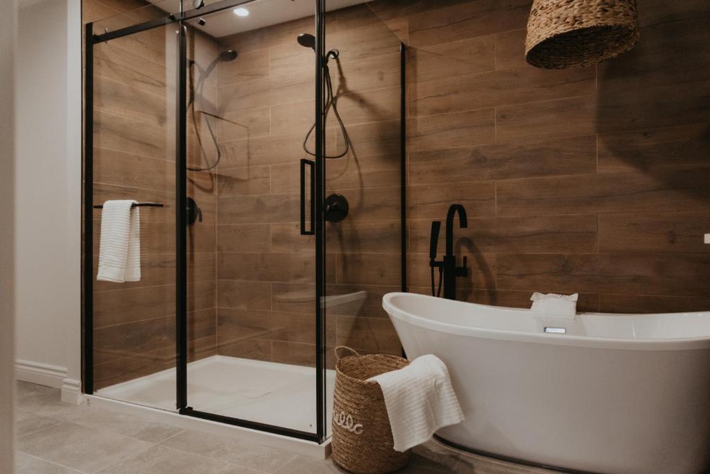 a bathroom with a tub and a glass shower at Le Mont Blanc 2 Ski In Ski Out in Saint-Faustin