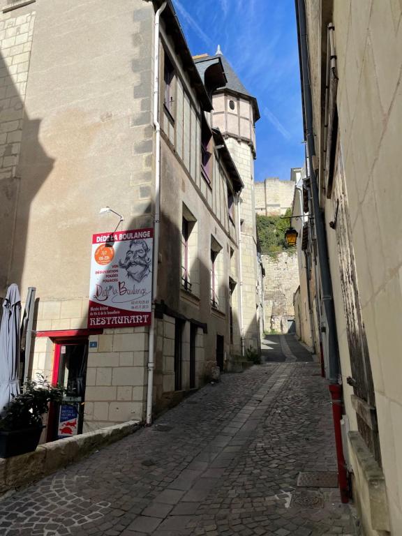 an alley with a building with a clock tower in the background at La chambre d'Henri II in Chinon