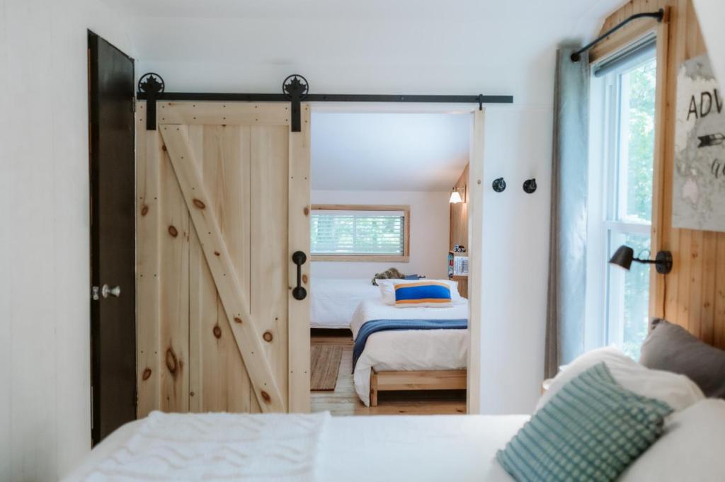 a bedroom with a sliding barn door with a bed at Le Grizzli Orford in Orford