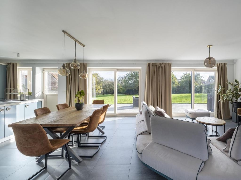 cocina y sala de estar con mesa de madera y sillas en Overijse Grande Residence, en Overijse