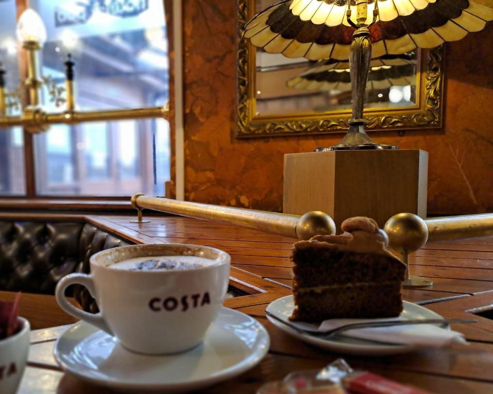 a piece of cake and a cup of coffee on a table at Villager Hotel, Ingoldmells in Ingoldmells