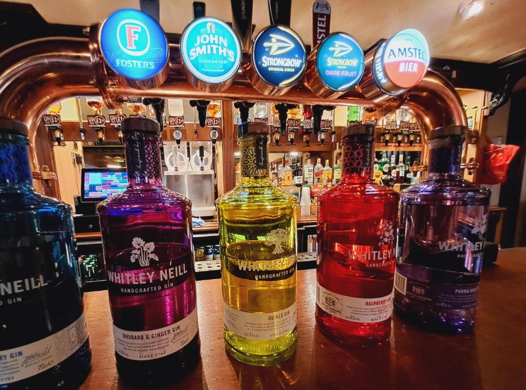 a group of bottles of alcohol sitting on a bar at Villager Hotel, Ingoldmells in Ingoldmells