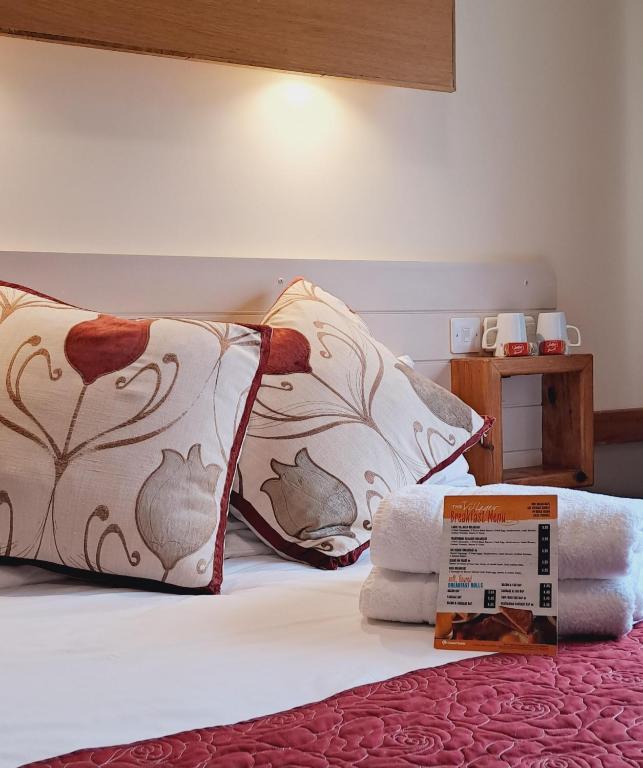a bed with two pillows and a box on it at Villager Hotel, Ingoldmells in Ingoldmells