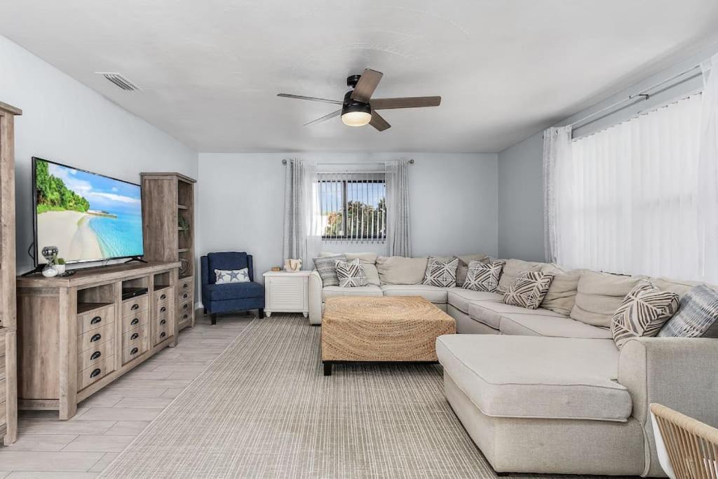 uma sala de estar com um sofá e uma televisão de ecrã plano em Charming Family Retreat Heated Pool Private Yard em Cape Coral