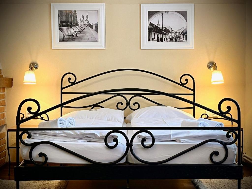 a bedroom with a black bed with two pillows at Antonio Old Town Residence in Prešov
