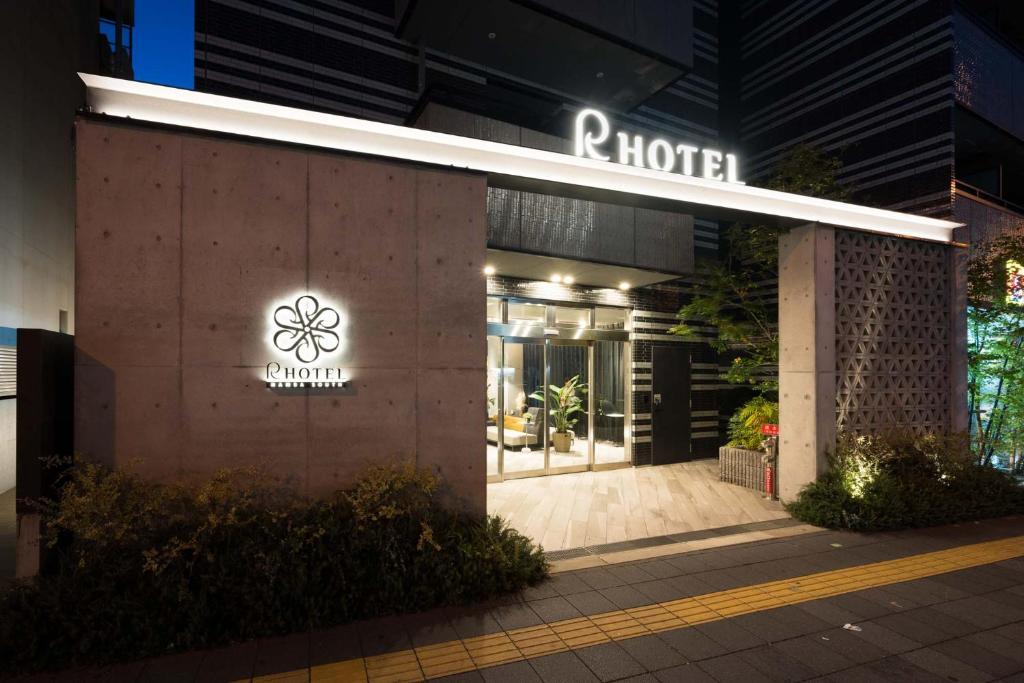 R Hotel Namba South في أوساكا: فندق فيه لافته على جانب مبنى