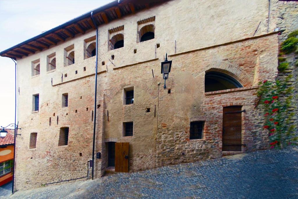 ein großes Backsteingebäude mit vielen Fenstern in der Unterkunft Palazzo d'Assi - Guest house in Monforte dʼAlba