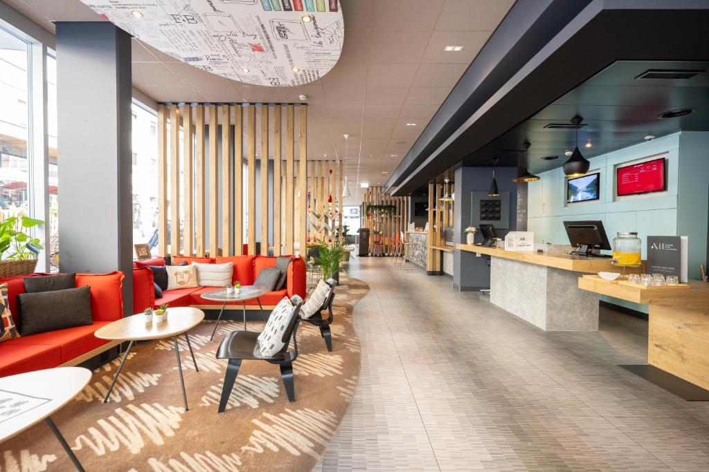 a lobby with couches and tables and a cafeteria at ibis Geneve Centre Lac in Geneva