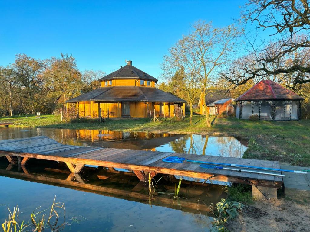 uma casa na margem de um lago com uma doca em Agroturystyka Złoty Klon 