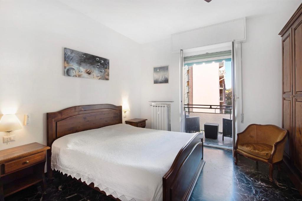1 dormitorio con 1 cama, 1 silla y 1 ventana en Il Gabbiano, en Albissola Marina