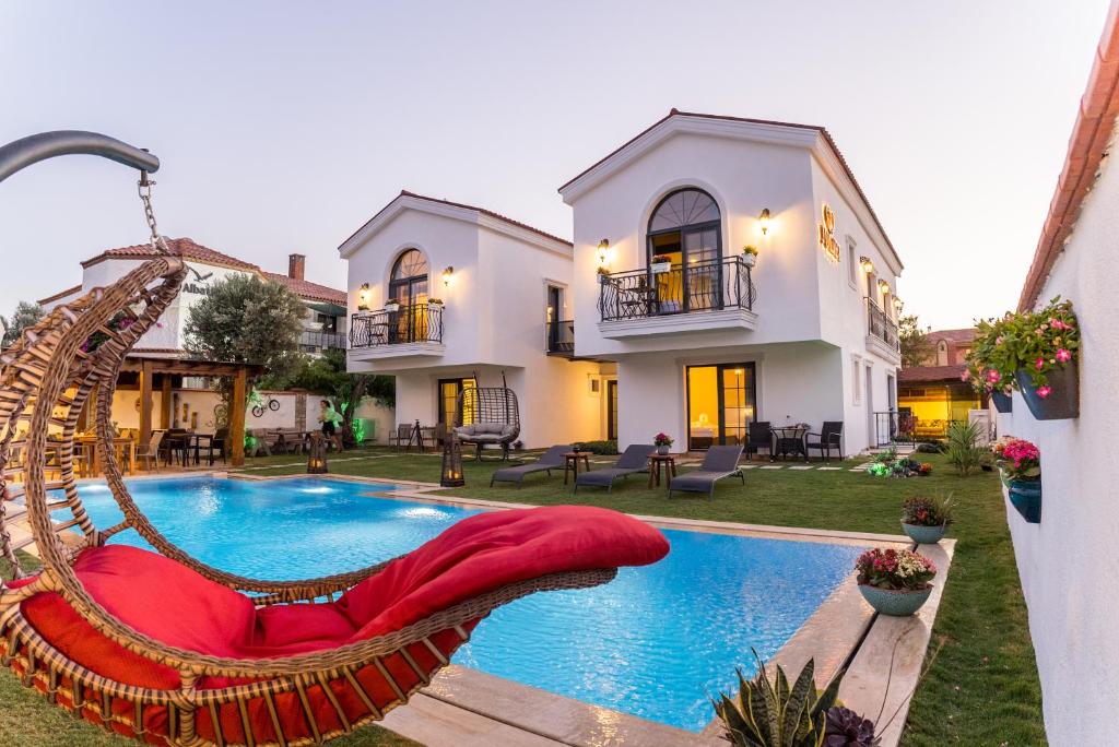 a villa with a swimming pool and a house at JULİETOTEL in Alaçatı