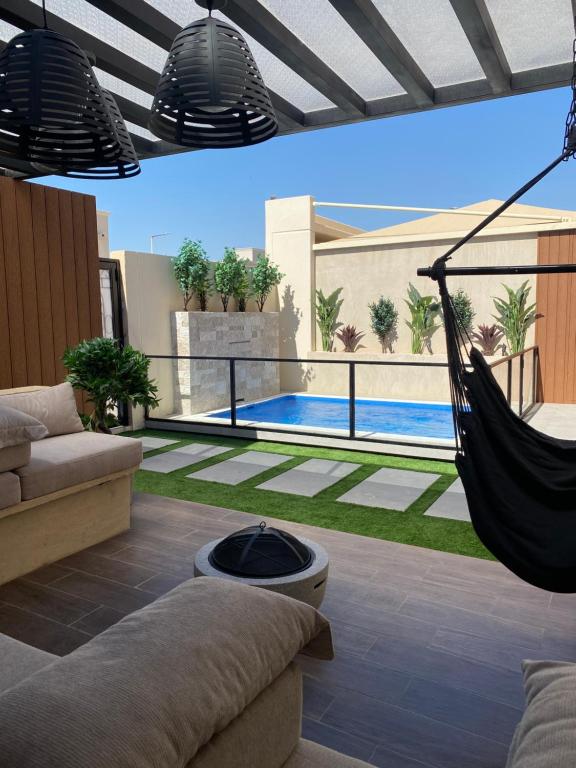 a patio with a hammock and a swimming pool at أكوا فيلا Aqua Villa in Madīnat Yanbu‘ aş Şinā‘īyah