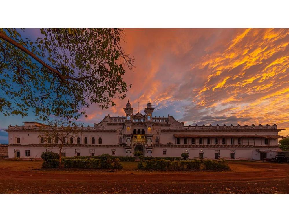 にあるKila The Heritage Palace, Kothiの夕日を背景に広大な白い建物