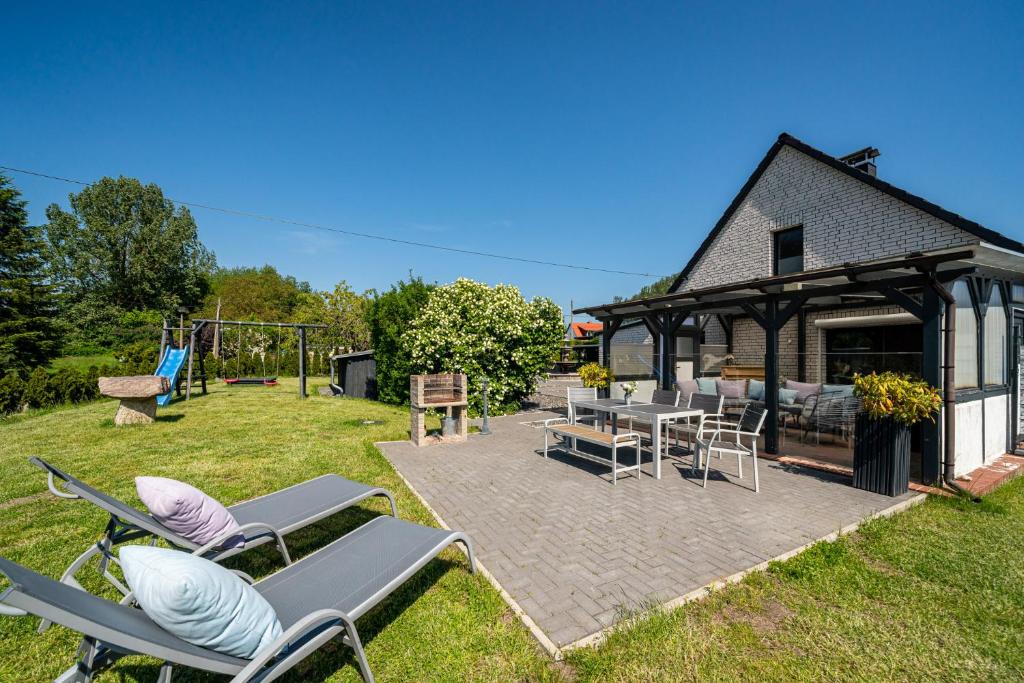 a backyard with chairs and a pavilion with a playground at Ferienhaus Landlust - Erholung mit Fasssauna und Whirlpool nahe Binz! in Zirkow