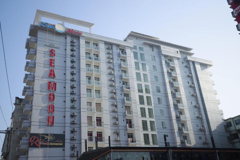 ein großes weißes Gebäude mit einem Schild drauf in der Unterkunft Hotel Sea Moon in Cox's Bazar
