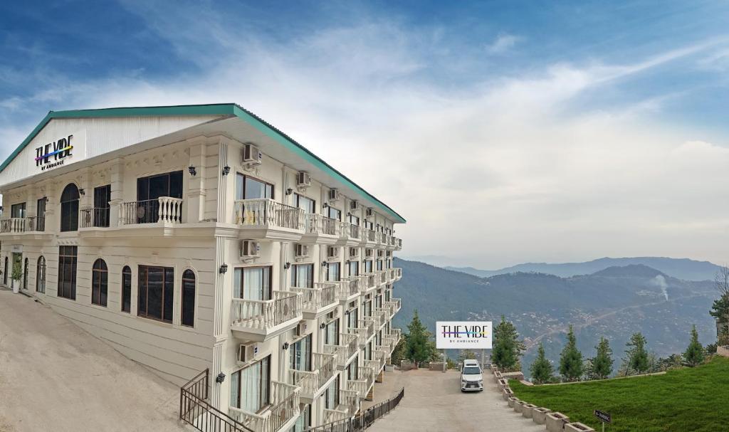 a large white building with a sign on the side of it at The Vibe By Ambiance in Murree