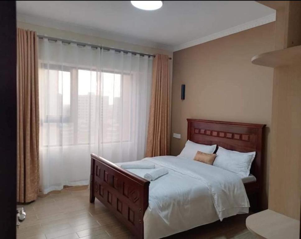 - une chambre avec un grand lit et une fenêtre dans l'établissement Ngao property, à Nairobi