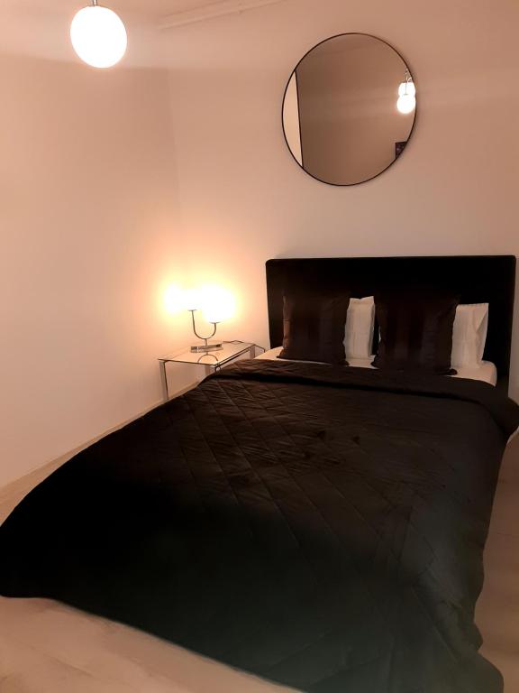 Schlafzimmer mit einem schwarzen Bett und einem Spiegel in der Unterkunft SUPER MIA PLUS!!! in Bukarest