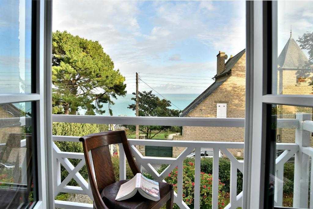 - une chaise sur le balcon donnant sur l'océan dans l'établissement La Brise Cancalaise - Maison typique avec vue mer, à Cancale